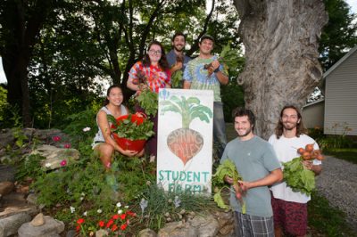 Students pose with vegetables at the Spring valley Student Farm